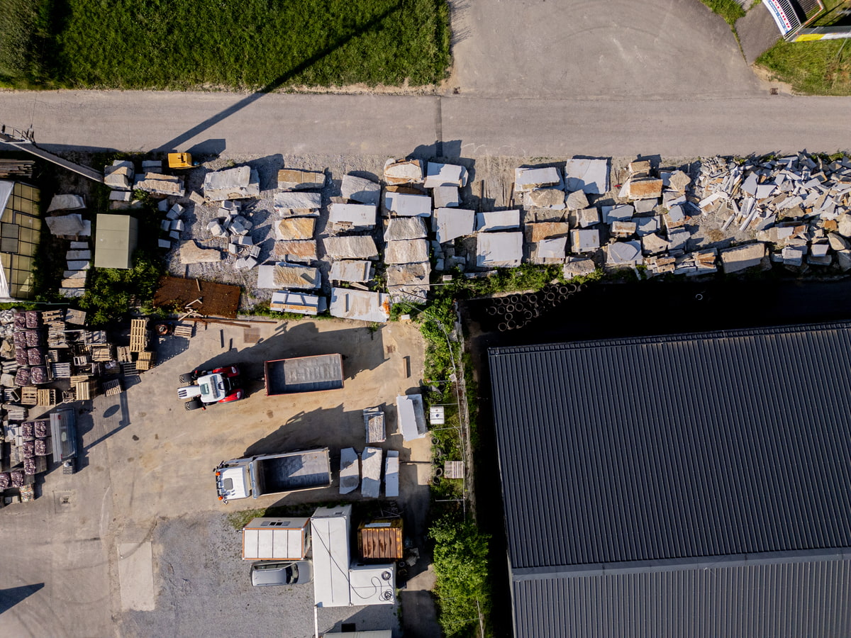 Luftaufnahme Gartencenter mit Gewächshäusern, Verkaufsflächen und bewaldeten Hügeln